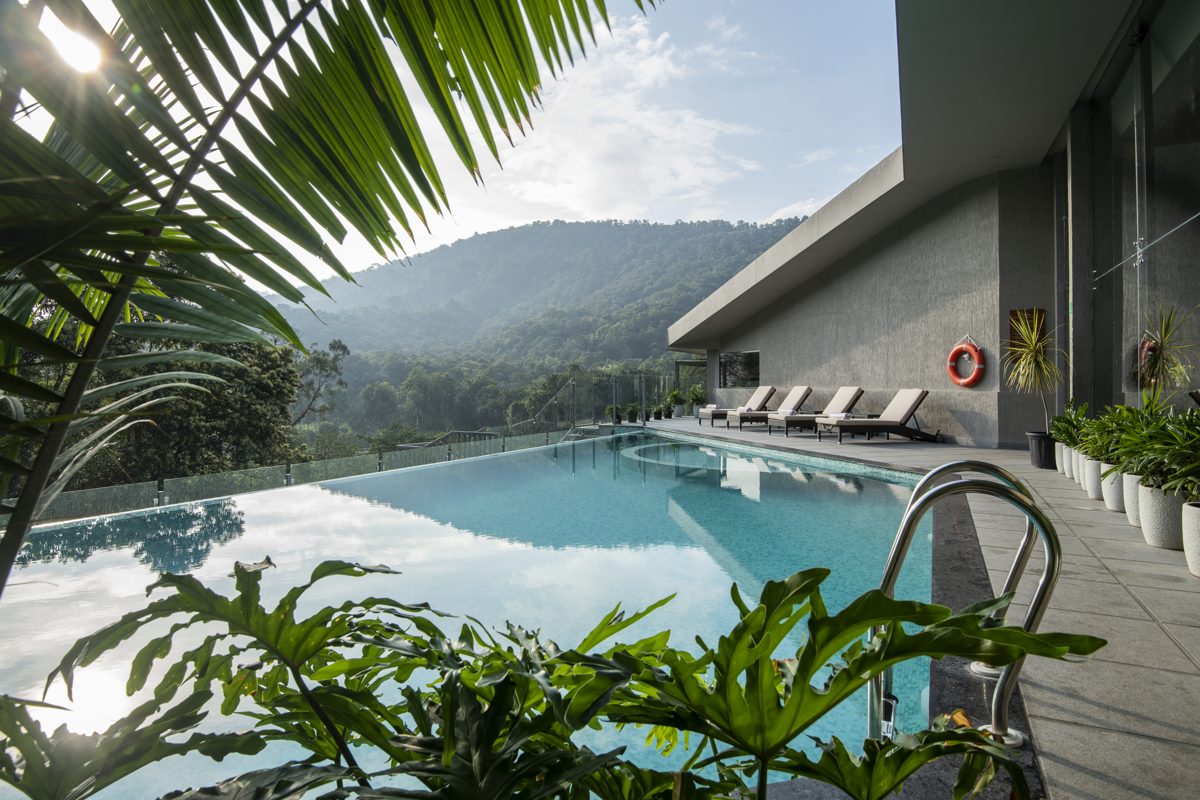 Samroha's pool surrounded by palms and forested hills